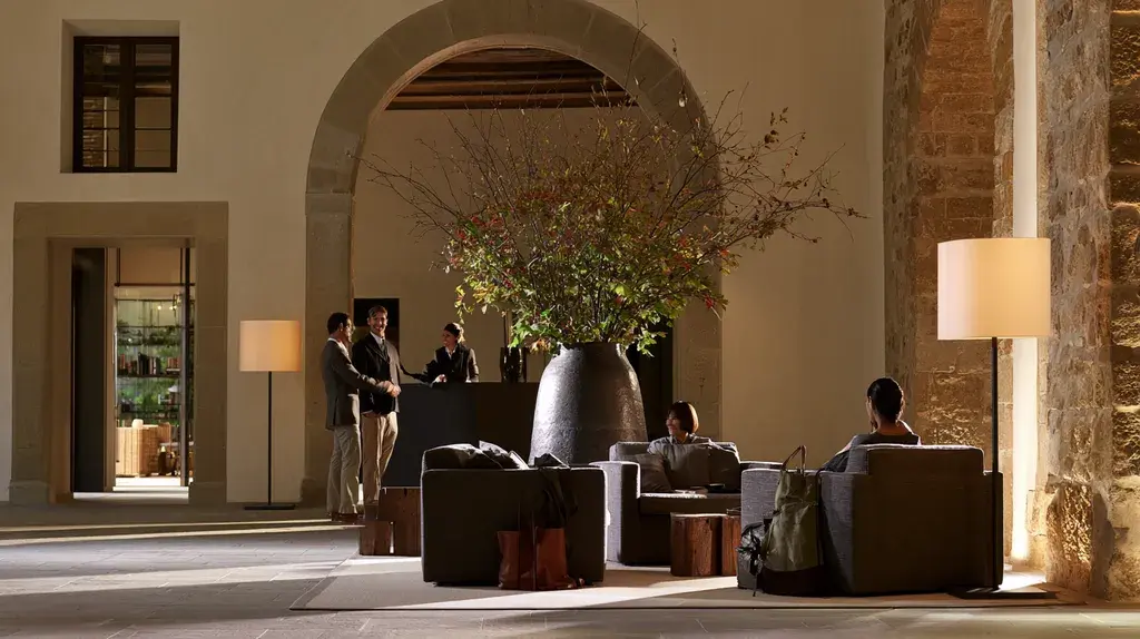 Guests arriving in a restored Italian hotel lobby with dedicated luxury travel support