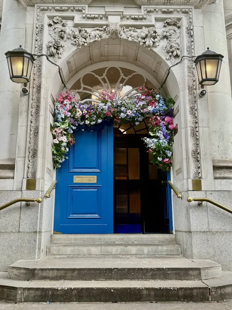 Flower-framed blue door, London, England